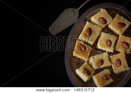 Homemade Basbousa from Above on Dark background with Copy Space