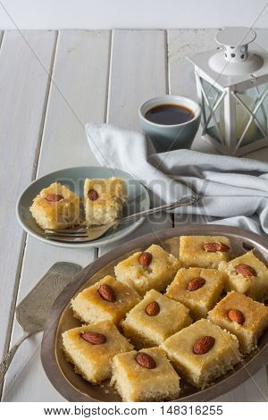 Homemade Basbousa with Coffee on White Wooden Table Vertical with Copy Space