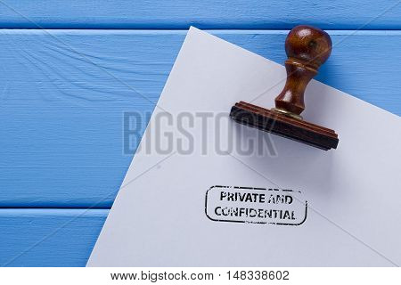 Stamp on a wooden surface and the imprint of a private and confidential.