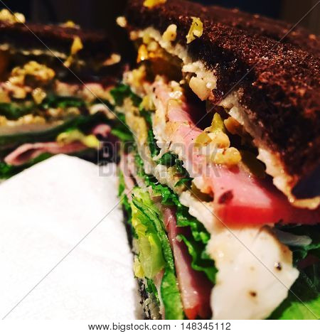 Giant sandwich on pumpernickel on plate on table