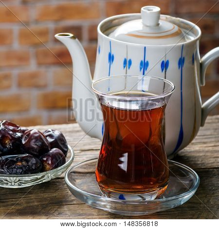 Tea with dates on wooden table. Selective focus