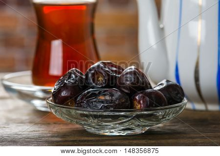 Tea with dates on wooden table. Selective focus