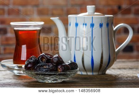 Tea with dates on wooden table. Selective focus