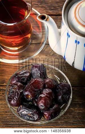 Tea with dates on wooden table. Selective focus