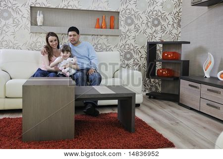 Happy youg familie afslappende i moderne stue derhjemme