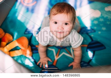 Cute Little Baby Boy Playing In Colorful Playpen, Indoors. Beautiful Child Having Fun At Nursery.