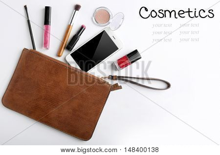 Makeup bag with beauty products and phone on white background