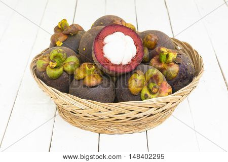 Mangoteen and mangoteen slice in the basket on wooden white background.Top view and zoom in.