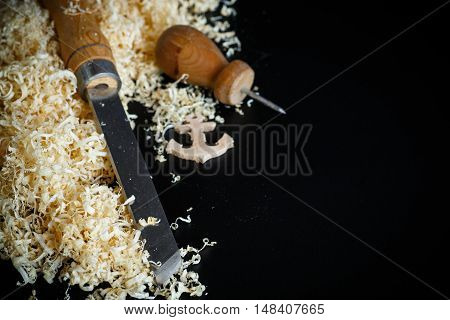 Woodworking tools. Chisel with sawdust on a black background.