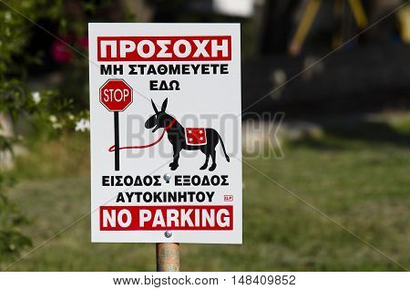 Sign for no parking in greek in graphic shows a donkey tied to a pole Stop