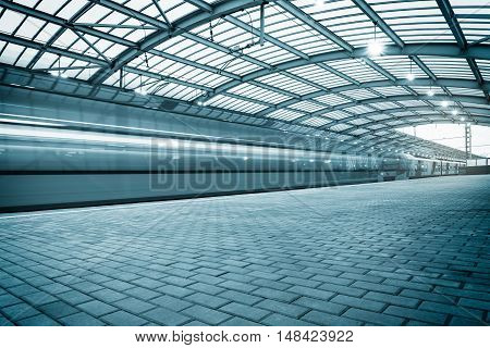 Modern high-speed train departs from the station at sunset.
