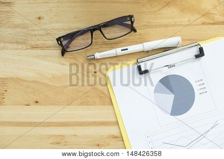 Top View Of  Analyze Chart, Glasses And Pen On Office Wooden Desktop.