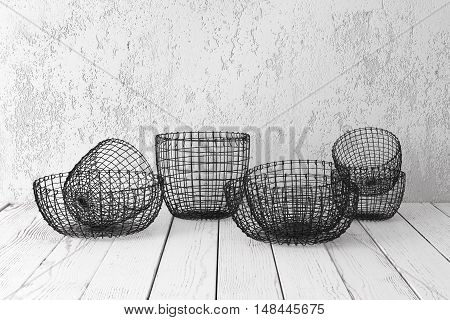 Vintage wire baskets on white wooden rustic floor industrial wicker storage bins