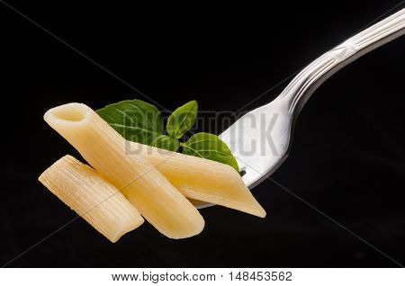 Pasta on the fork on the black background
