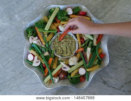 Vegetable Crudites and Dip/ vegetable platter on wood background, woman snacking, healthy eating, selective focus