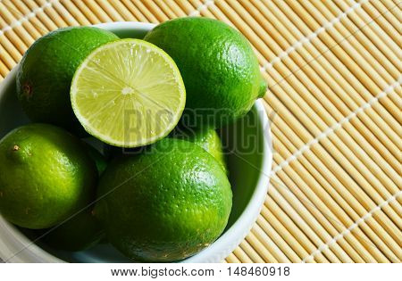 fresh cut lime in a bowl on bamboo mat