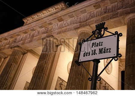 Platz des 18. Marz sign and Brandenburg gate at night in Berlin Germany