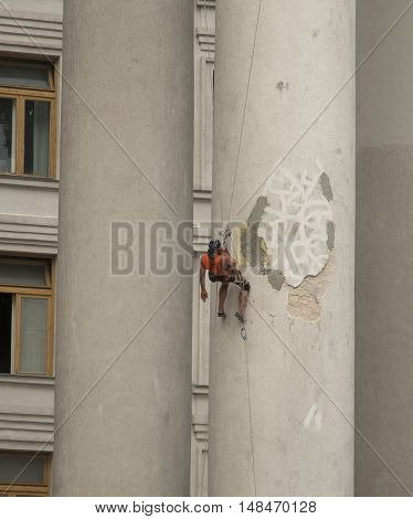Industrial climber talking on the phone at the height of