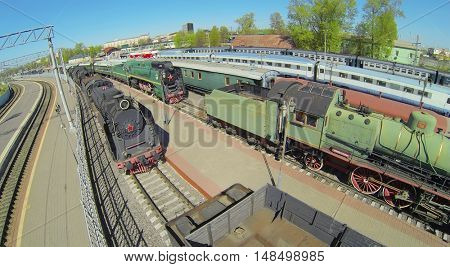 Old trains on the tracks at a railway station on a sunny day, aerial view