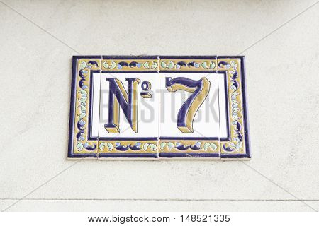 Number seven on the wall of a house detail of a number of information odd number