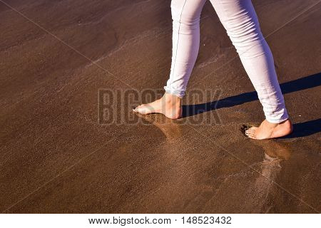 Lonely woman walking along on the beach