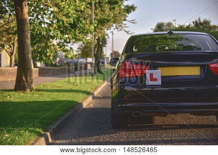 A car with the L plates on ready for a new driver to use.