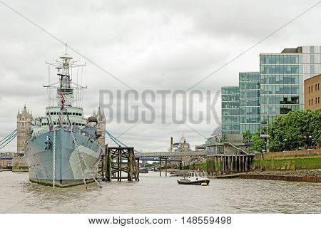 LONDON UK - JULY 8 2016: HMS Belfast (Royal Navy light cruise) - a warship Museum with Tower bridge at the back. Belfast moored in London on River Thames and operated by the Imperial War Museum.