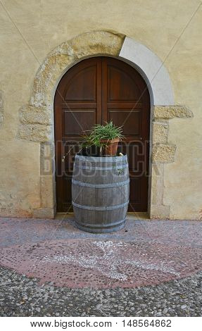A wooden barrel outside an old wooden door in the small north east Italian town of Valvasone in Friuli Venezia Giulia