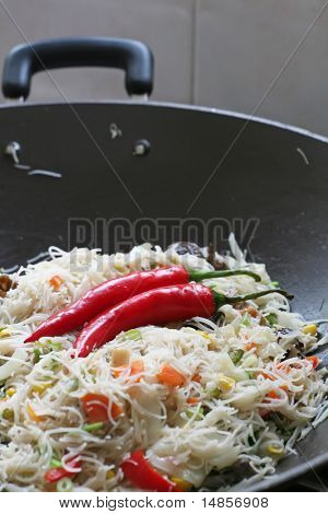 En tallerken med stegt asiatiske nudler i wok med chillis