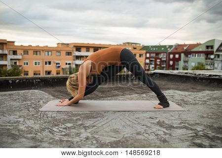 Woman practicing yoga on the roof,Parsvottanasana /Intense side stretch