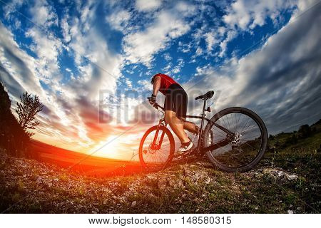 Cyclist Riding Mountain Bike On Rocky Trail At Sunrise