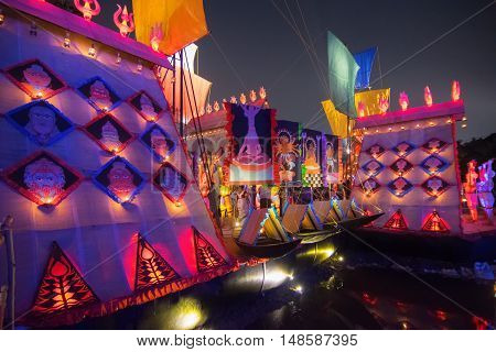 KOLKATA INDIA - OCTOBER 21 2015 : Beautiful exterior of decorated Durga Puja pandal at night Howrah West Bengal India. Shot under colored lights. Durga Puja is biggest religious festival of Hinduism.