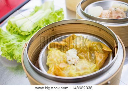 dim sum - Crab Dumplings in bamboo basket on table blur background