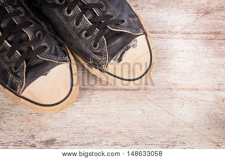 old black canvas shoes on wooden background