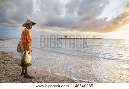Bali Indonesia September 11th 2016: old fisherman on the beach with his fish nets