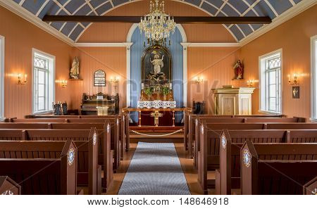 Strandakirkja Iceland - June 25 2016: Interior of the Strandakirkja church with red benches and blue painted ceiling with yellow stars in Iceland.