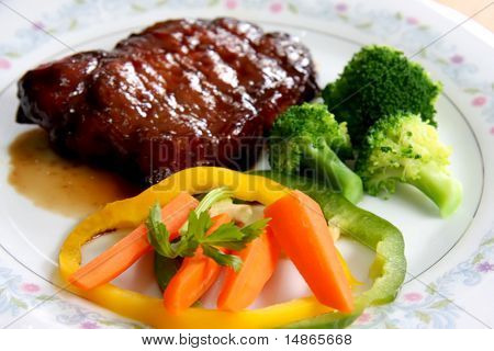 Porkchops กับน้ำซอสราดหน้าผักในจาน