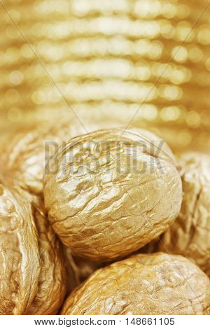 Golden walnuts against bokeh background, finance or money concept.