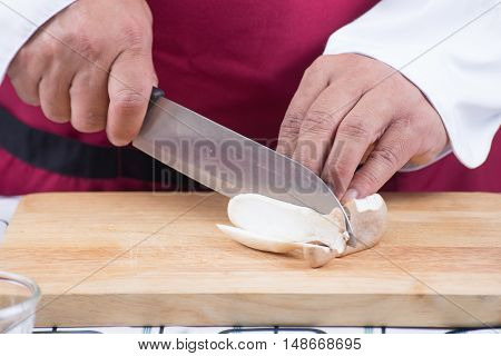 Chef slicing eringi for cooking / cooking stir fry vegetarian noodle concept