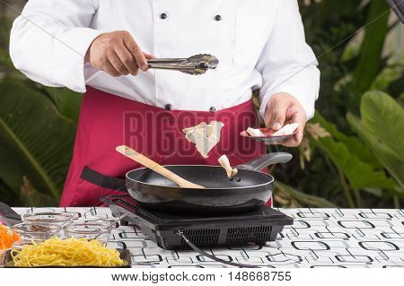 Chef putting eringi for cooking / cooking stir fry vegetarian noodle concept