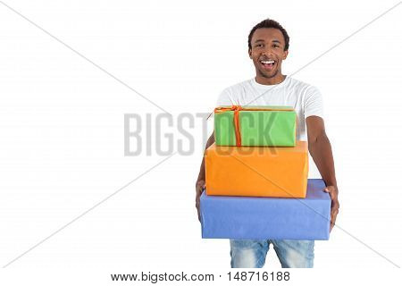 Front view of cheerful African American man holding a stack of packed gifts. Concept of bithday party. Mock up