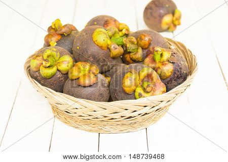 Mangoteen and  in the basket on wooden white background.Top view and zoom in.
