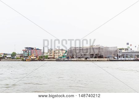 Bangkok Thailand - June 5 2016: Right hand side of Chao Phraya River on cloudy day with construction site. It is at the same side of Siriraj Hospital part of Mahidol university.