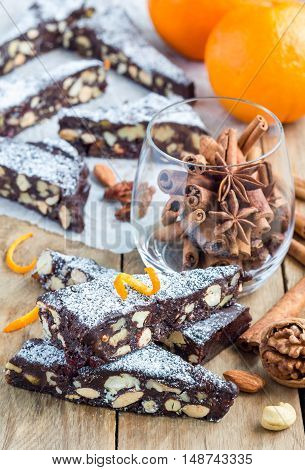 Panforte traditional italian christmas dessert with nuts and candied fruits on parchment vertical