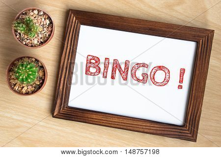 Bingo, text message on wood frame board on wood table / business concept / Top view