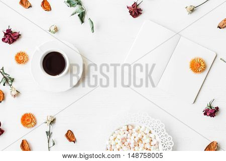 Autumn composition. Workspace with notebook cup of coffee autumn leaves and dried rose flowers. Top view flat lay