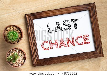 last chance, text message on wood frame board on wood table / business concept / Top view