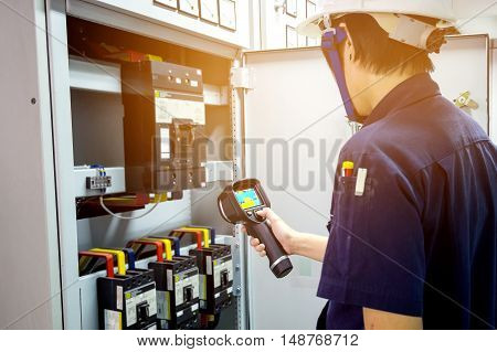 technician use thermal imaging camera to check temperature in factory