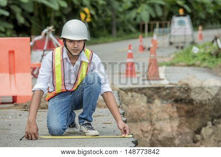 Engineer checking damaged road asphalt concrete design
