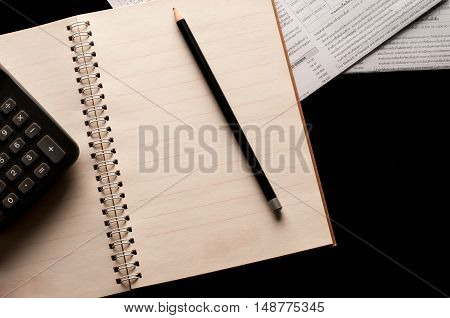 Stationary, Notebook, pencil and calculator use in business office black background